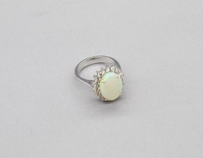 null Bague en or gris 18K (750) sertie d'une opale ovale entourée de diamants (acc).

Poinçon...