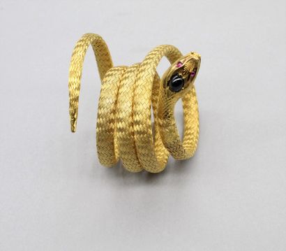 null 
Bracelet en or jaune 18K (750) figurant un serpent, la tête ornée d'un cabochon...