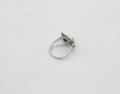 null Platinum ring set with a rectangular emerald and two trapeze-shaped diamonds...