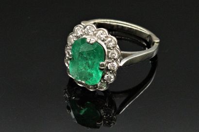null 18K (750) white gold ring set with a cushion-shaped emerald surrounded by round...