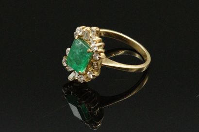null 18k (750) yellow gold ring set with a rectangular emerald in a circle of round...