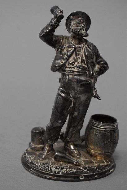 null 
Two silver statuettes (950) on an oval base, one representing a peddler holding...