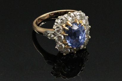 null 18K (750) gold ring, set with an oval sapphire surrounded and shouldered with...