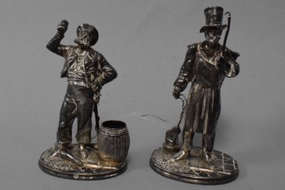 null 
Two silver statuettes (950) on an oval base, one representing a peddler holding...