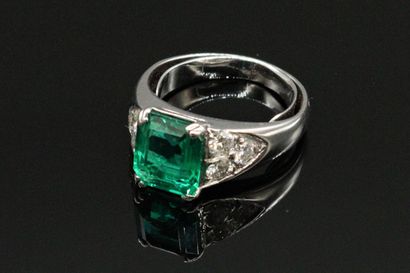 null 
18K (750) white gold ring, set with a rectangular emerald with cut sides weighing...