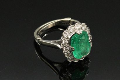 null 18K (750) white gold ring set with a cushion-shaped emerald surrounded by round...