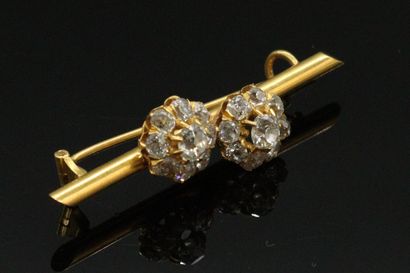 null Broche en or 18K (750), ornée de deux fleurs stylisées serties de diamants de...