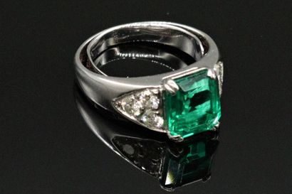 null 
18K (750) white gold ring, set with a rectangular emerald with cut sides weighing...