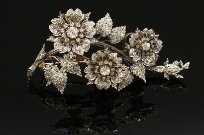 null Silver and 18K (750) gold brooch drawing flowers and foliage, set with old-cut...