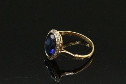 null 18K (750) white gold ring set with an oval synthetic sapphire surrounded by...