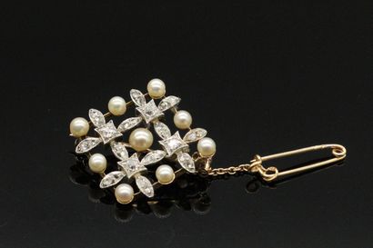 null 
Brooch in 18K (750) gold and platinum drawing a stylized snowflake set with...