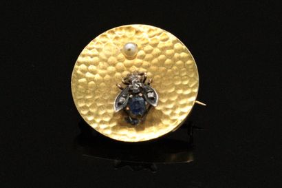 null Round brooch in 18K (750) gold, decorated with a silver fly, the body in sapphire,...