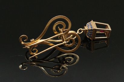 null Textured 18K (750) gold clip holding a mobile lantern decorated with round sapphires...