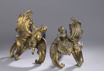 null Pair of gilt bronze andirons featuring a young man and a young woman sitting...