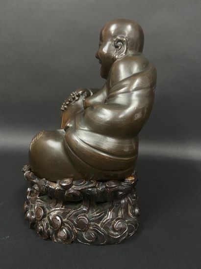 null Bouddha en bronze tenant dans sa main un chapelet, son vêtement décoré de signes...