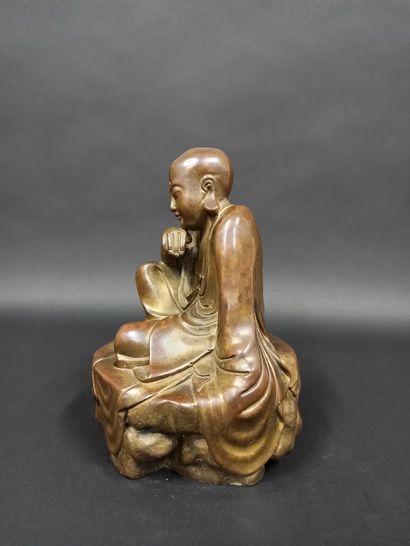 null Arahat en bronze en position de délassement assis sur un rocher.

Chine, XXème...