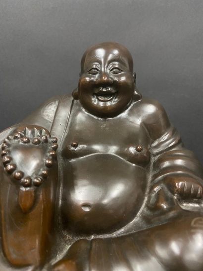 null Bronze Buddha holding in his hand a rosary, his garment decorated with shu signs...