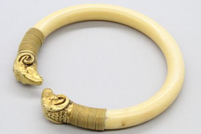 null Bracelet rigide ouvert, les extrémités à décor d'une tête de bouc en or jaune...