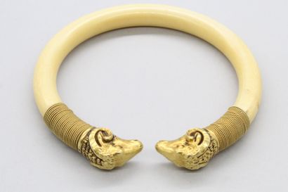null Bracelet rigide ouvert, les extrémités à décor d'une tête de bouc en or jaune...