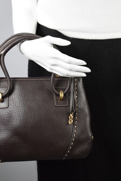 null ESCADA SPORT 



Brown leather handbag, apparent white stitching, gold jewelry....