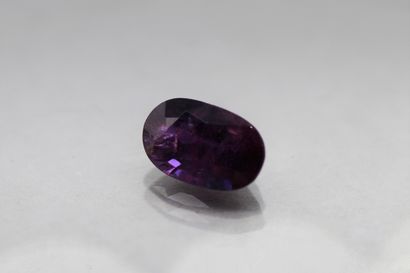 Oval purple sapphire on paper.

Accompanied...
