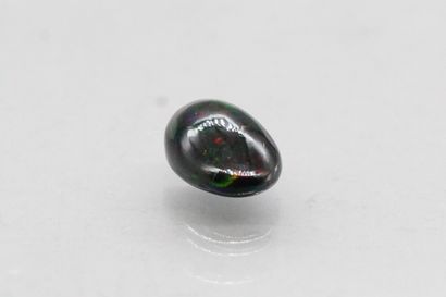 null Opal cabochon on paper.

Accompanied by a certificate indicating treated black....