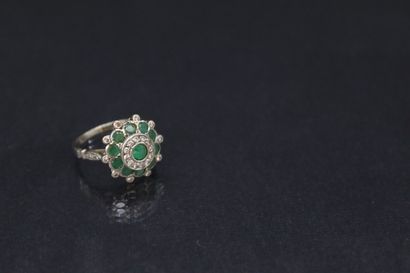 null Bague en or gris 18k (750) stylisant une fleur ornée d'émeraudes et de petits...