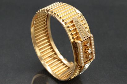 null Cuff bracelet in 18K (750) yellow gold with a wavy band and a pyramidal pattern...