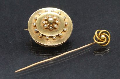 null Lot including: 

- An 18k (750) yellow gold tie pin set with a small pearl.

Eagle...