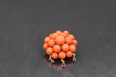 null Broche en or jaune 18k (750) et boules de corail décorée de trois petites pampilles....