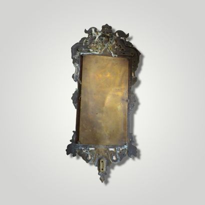 null Petit miroir biseauté, le cadre en bronze, le fronton à décor de deux chimères...