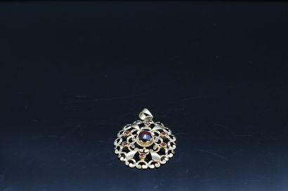 null 18K (750) yellow gold openwork pendant set with a faceted garnet in its center.

Gross...