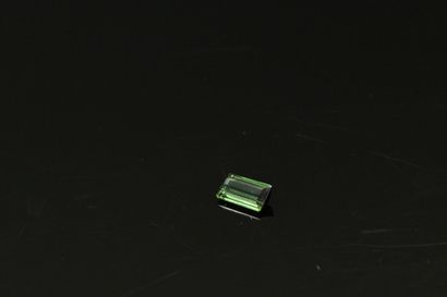 null Rectangular green tourmaline with cut sides on paper. 

Weight : 1.20 cts.
