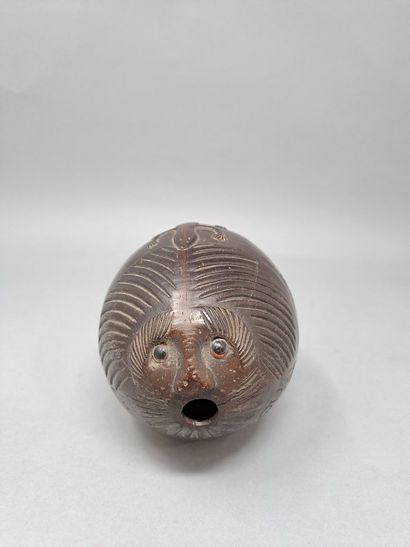 Coconut powder flask featuring a grotesque,...