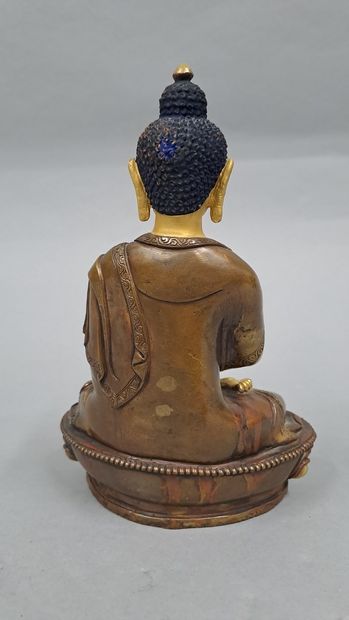 null Bouddha en bronze doré et patiné tenant entre ses mains un pot couvert.

Cambodge...