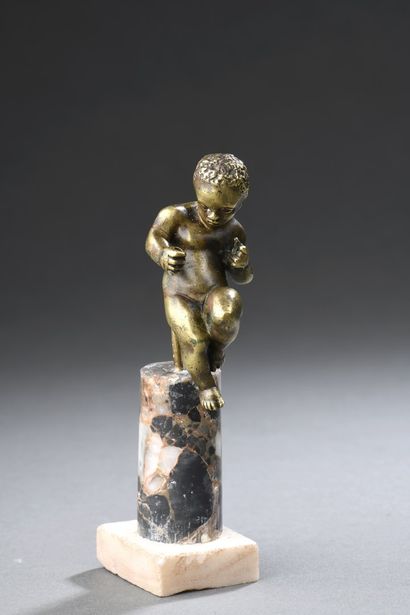 null Gilded bronze Cupid with curly hair represented seated, left leg bent, stretching...