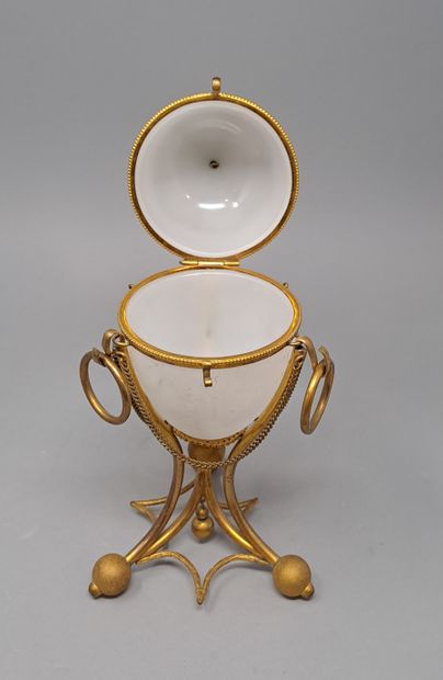 null Opaline glass ovoid box, gilded metal frame resting on three feet balls joined...