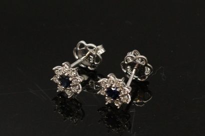null Pair of 18k (750) white gold daisy ear studs set with a round sapphire in a...