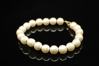 null Fancy pearl bracelet holding a tassel with the inscription "CHANEL".
The clasp...