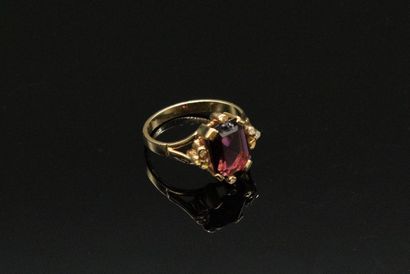 null 18K (750) yellow gold ring set with a glass garnet doublet and three small white...