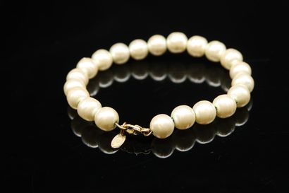 null Fancy pearl bracelet holding a tassel with the inscription "CHANEL".
The clasp...