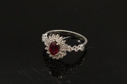 null Daisy ring in 18k (750) white gold set with an oval ruby in a double border...