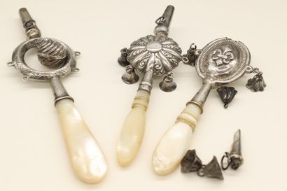 Set of three chased silver rattles forming...