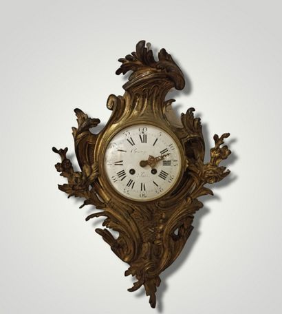null Wall clock in gilt bronze and chased with rocaille decoration. White enamel...