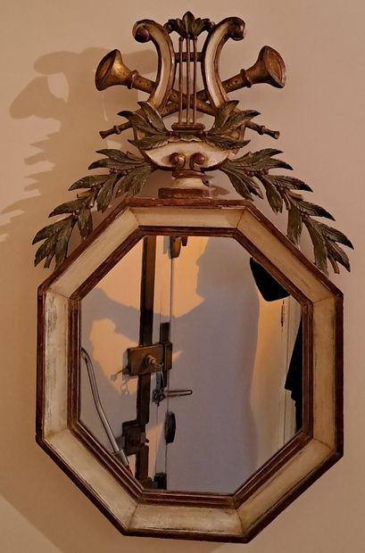 null Miroir octogonal en bois rechampi à fronton orné d’une lyre, de deux trompes...