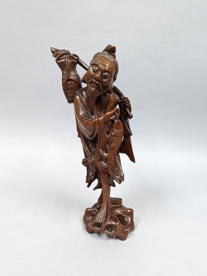 null CHINA - Early 20th century
Statuette of a standing fisherman in wood, holding...