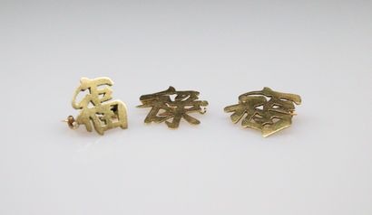 null Suite de trois caractères chinois montés en broche en or jaune 18k (750).
Poids...