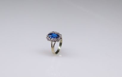 null 18k (750) white gold ring set with a synthetic blue stone in a circle of white...