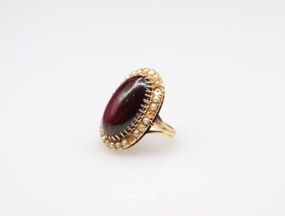 null 18k (750) yellow gold ring set with a garnet cabochon in a pearl setting. 
Finger...