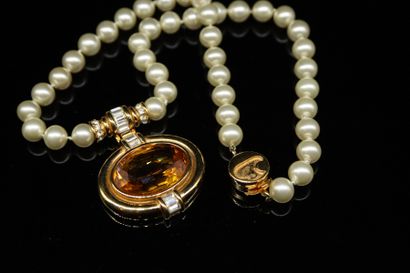 null CARVEN
Circa late 1970

Pearl necklace, an oval pendant set with a stone in...